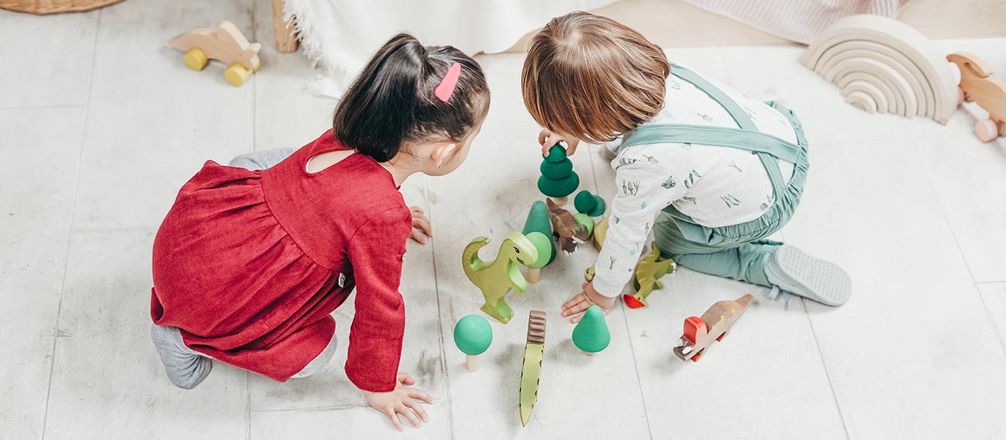 Toddlers playing with wooden toys