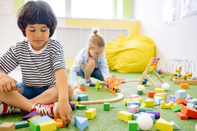 Young children playing with wooden toys